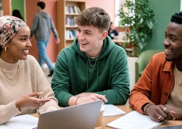 trois étudiants échangeant autour d’une table